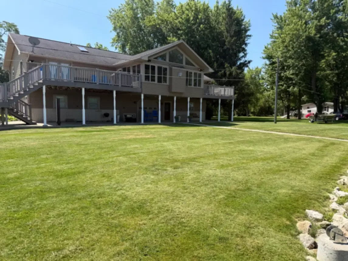 Residential lawn service with a striped lawn at a lakefront home in Fulton, Illinois